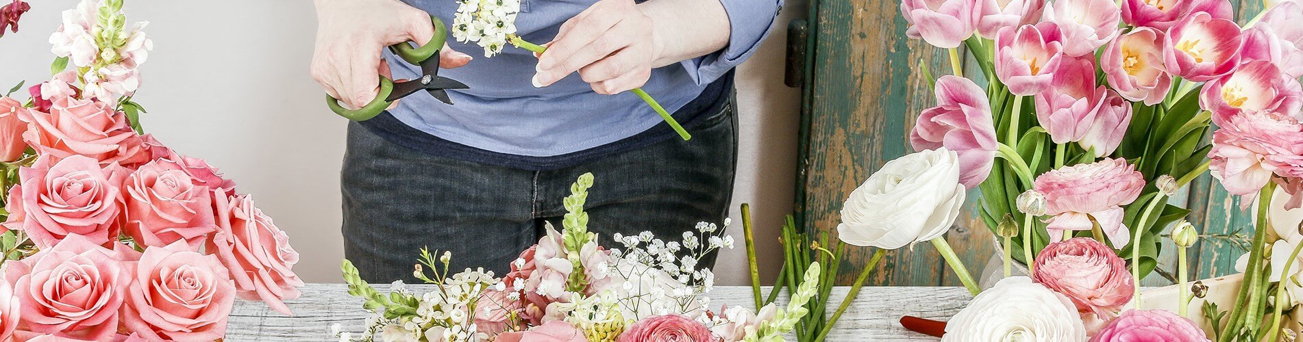 Roze tulpen en witte ranonkels op de werktafel